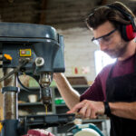 Industrial Maintenance Technician using a drill press.